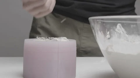 Concrete is inserted into a silicone mold to create a handmade candle Stock Footage 182941007