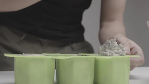 Concrete is inserted into a silicone mold to create a handmade candle Stock Footage 183881529