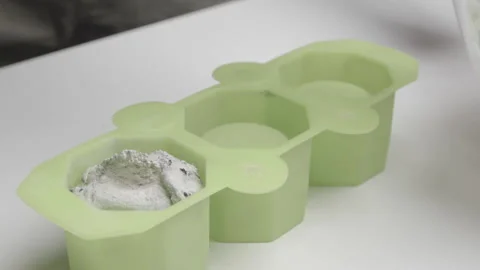 Concrete is inserted into a silicone mold to create a handmade candle Stock Footage 183918172