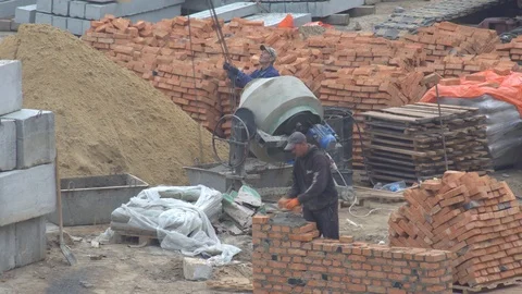 Concrete mixer on a building. the builder puts a brick wall. the builder builds Video stock 120674292