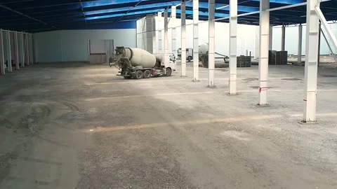 A concrete mixer at a construction site inside a large factory. A concrete mixer Vídeos de archivo 330198099