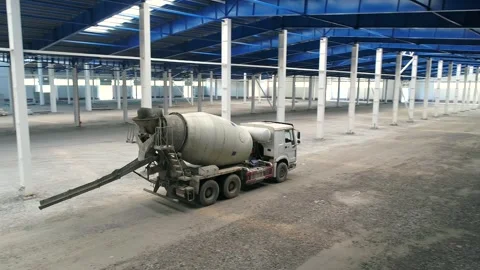 A concrete mixer at a construction site inside a large factory. A concrete mixer Vídeos de archivo 330198358