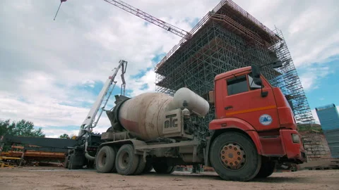 Concrete truck chute pouring wet cement Mix into metal bucket