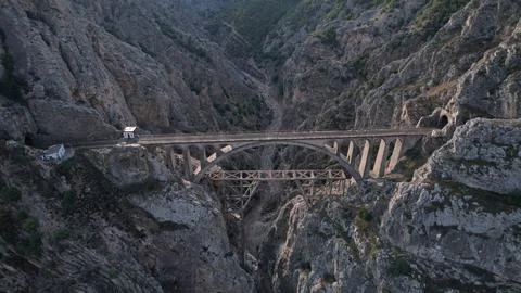 Concrete mountain bridge spans a deep Iranian gorge as a vehicle crosses, Stock Photos