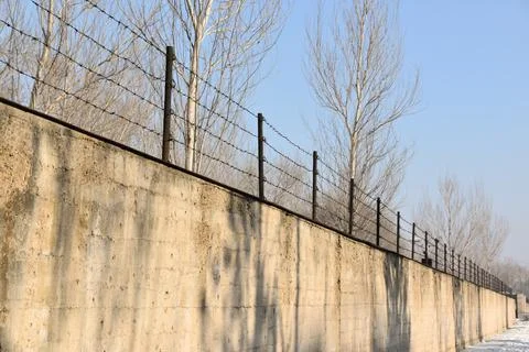 Concrete outer wall and barbed wire fence surrounding Unit 731 in Harbin Foto stock