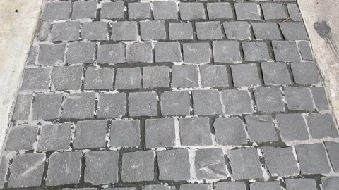 Concrete path with square stone blocks in grid layout viewed Stock Footage 313475974