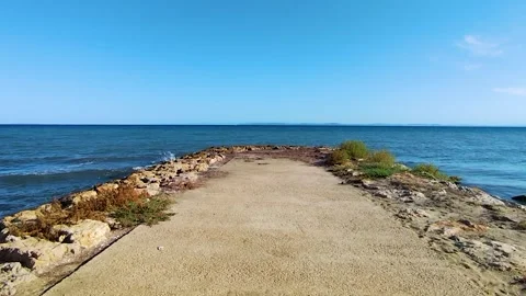 Concrete Pier Extending into the Deep Blue Sea under a Vast Clear Sky Stock Footage 322916967