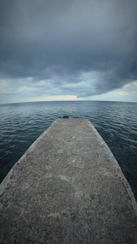 Concrete pier in the middle of the sea under a stormy sky Stock Footage 299530037