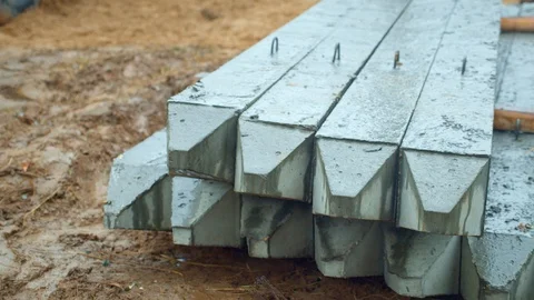 Concrete piles laying on the ground at the construction site. It is raining. Stock Footage 129101862