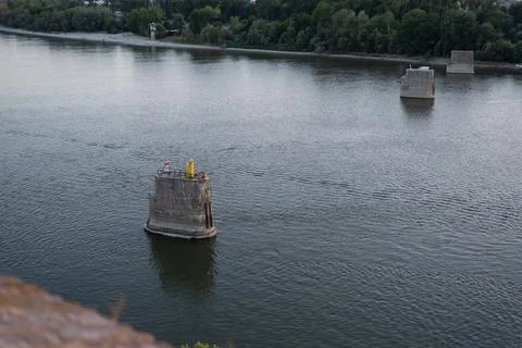 Concrete pillars of a destroyed bridge stand in the Danube River Stock Photos