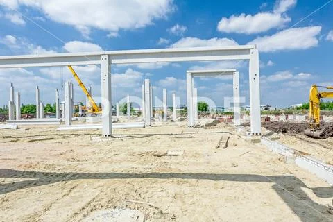Concrete pillars of new edifice with a beautiful sky are placed on sandy grou Stock Photos
