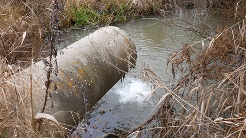 Concrete pipe transporting the polluted water to a small pond Stock-Footage 119887577