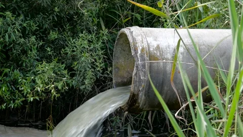 Concrete pipe transporting the smelly polluted sewage water Stock Footage 135700667