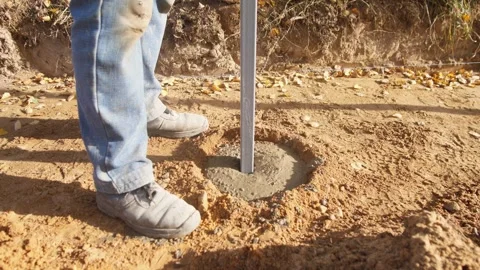 Concrete post installation, installing fence post in wet concrete, setting fence Stock Footage 319692470