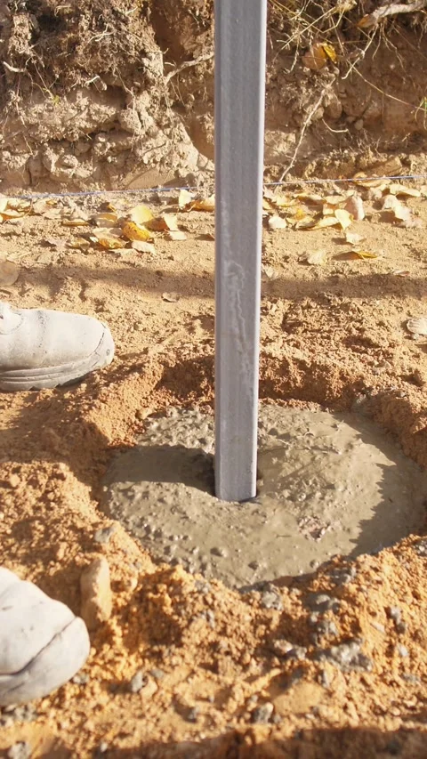 Concrete post installation, installing fence post in wet concrete, setting fence Stock Footage 319704771