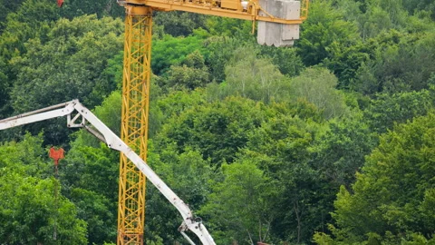 Concrete pump arm pours cement mixture on construction site roof.  Stock-Footage 342763938
