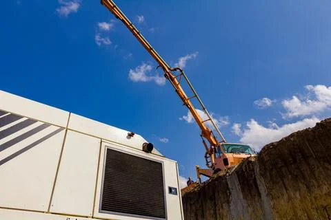 Concrete pump placed on higher level than building site Stock Photos