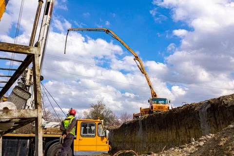 Concrete pump placed on higher level than building site Stock Photos
