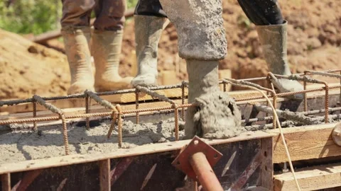 Concrete pump pouring wet cement into foundation formwork Stock Footage 341294797