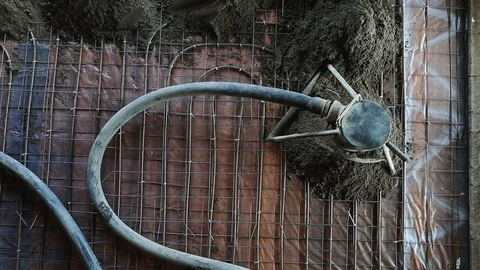 Concrete pump tool in action laying cement over underfloor heating system Stock Footage 128196823