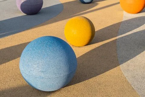 Concrete spheres Colorful objects of different sizes rest on a textured sur.. Stock Photos