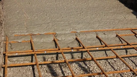 Concrete is spreading in foundation over reinforcing steel bars. Stock Footage