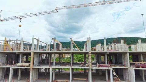 Concrete structure being assembled with machinery and safety measures. Aerial Stock Footage 340144869