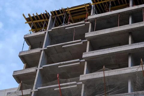 Concrete structure rises under clear blue sky. Steel beams and wooden forms.. Foto stock