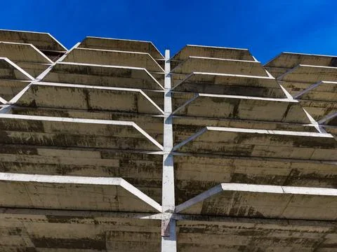 Concrete structure under bright blue sky with clear lines and geometric shapes Stock Photos