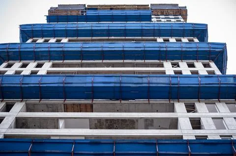 Concrete structure of urban building construction site with blue protective.. Stock Photos