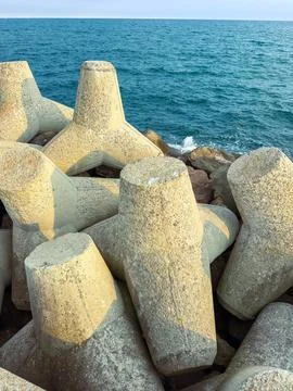 Concrete structures by the shore protect the coast from waves at a seaside .. Stock Photos