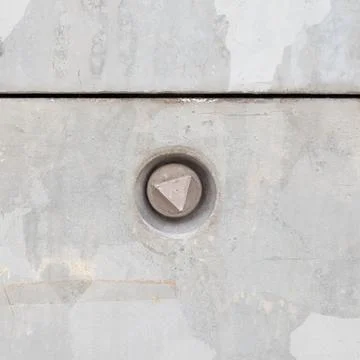 Concrete surface featuring circular indentation with triangular bolt Stock Photos