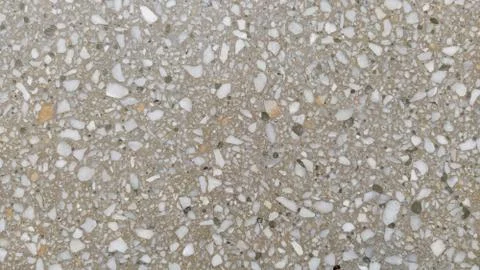Concrete surface with multi-colored blotches of small stones. Light beige ton Stock Photos