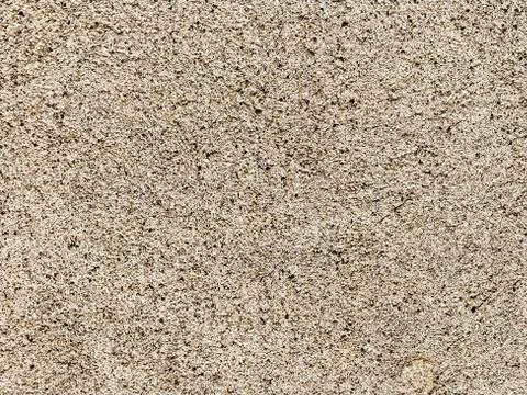 Concrete surface with multi-colored blotches of small stones. Light beige ton 스톡 사진