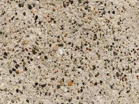 Concrete surface with multi-colored blotches of small stones. Light beige ton Stock Photos