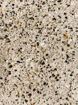 Concrete surface with multi-colored blotches of small stones. Light beige ton Stock Photos