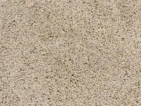 Concrete surface with multi-colored blotches of small stones. Light beige ton Stock Photos
