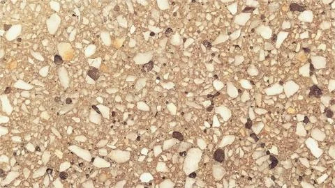 Concrete surface with multi-colored spots of small stones. Beige or orange to Stock Photos