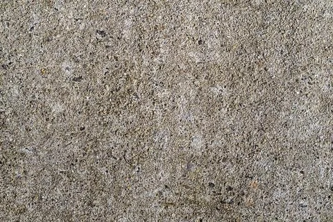 Concrete texture closeup with rough gray surface and embedded stones for Stock Photos