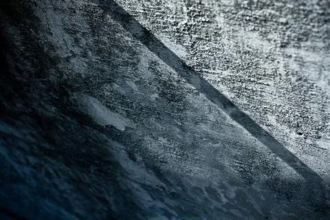 Concrete textured wall with the shadow of a pole running across it Stock Photos
