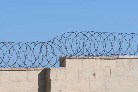 Concrete wall with barbed wire at a protected area Foto stock