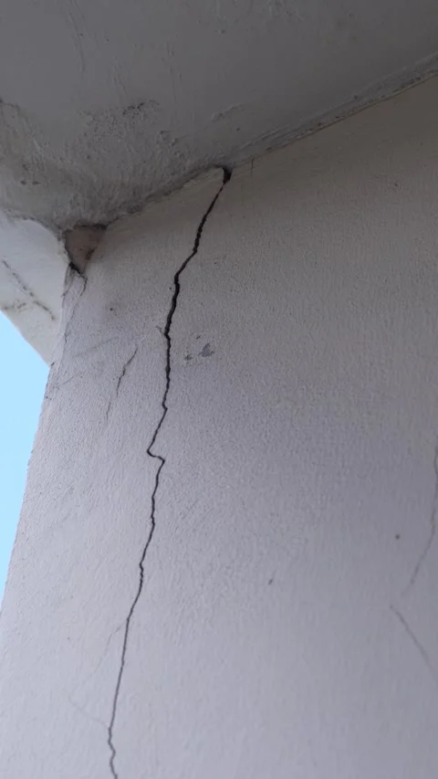 Concrete wall corner showing a prominent vertical crack along the wall surface Stock Footage 346334272
