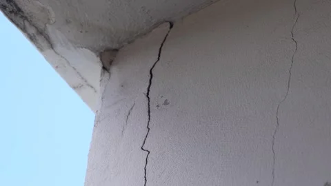 Concrete wall corner showing a prominent vertical crack along the wall surface Stock Footage 346334285