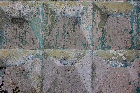 A concrete wall with a pattern of square blocks. An old tiffany-colored concr Stock Photos