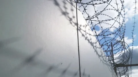 Concrete wall of the prison with barbed wire under high voltage. Elegant panning Stock Footage