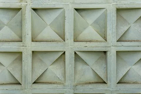 Concrete wall with a repetitive geometric pattern of protruding pyramidal shapes Stock Photos