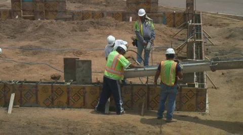 Concrete workers push wet cement down chute. Stock Footage 134950