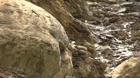 Concretion rock formations in side of stone cliff zoom out Stock Footage 65100234