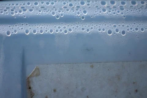 Condensation droplets on a plastic container surface with a label 库存照片