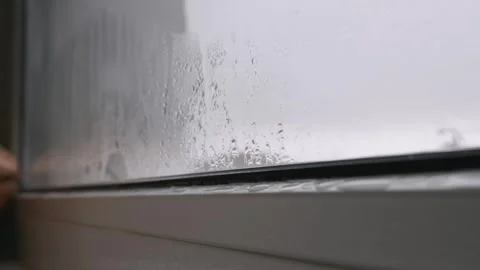 Condensation Water Drops Running Down a Cold Window Pane Stock Footage 324957922
